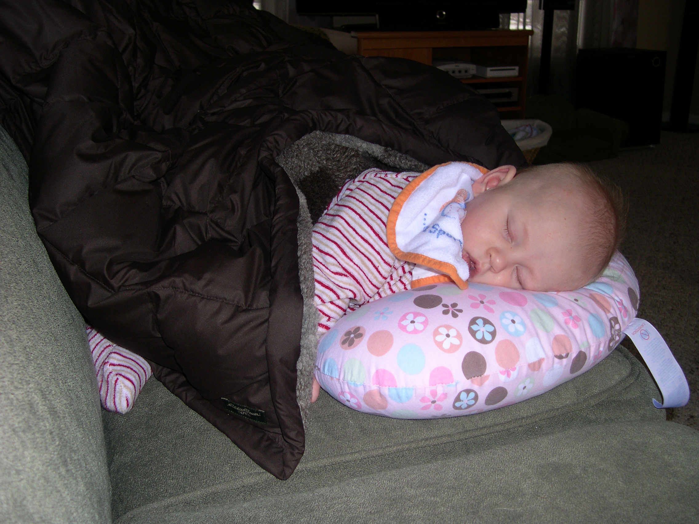 Nicky sleeping in the Boppy while Mommy and Daddy clean up the Christmas stuff