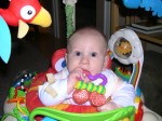 Nicky with a teething ring in the Jumperoo