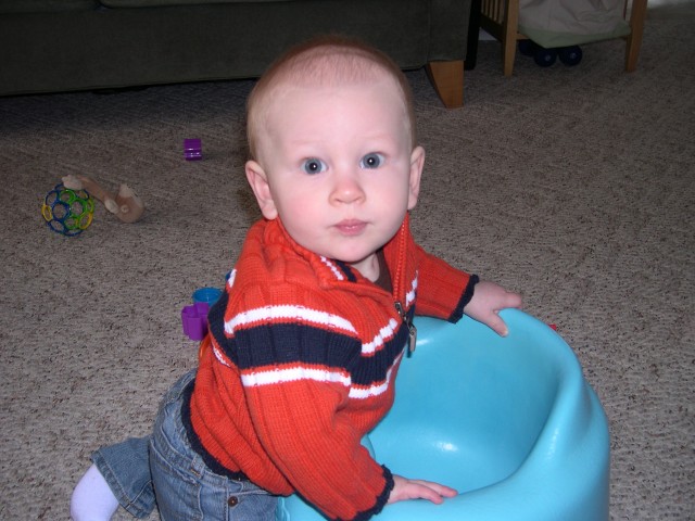 Using the Bumbo seat to pull himself into a standing position