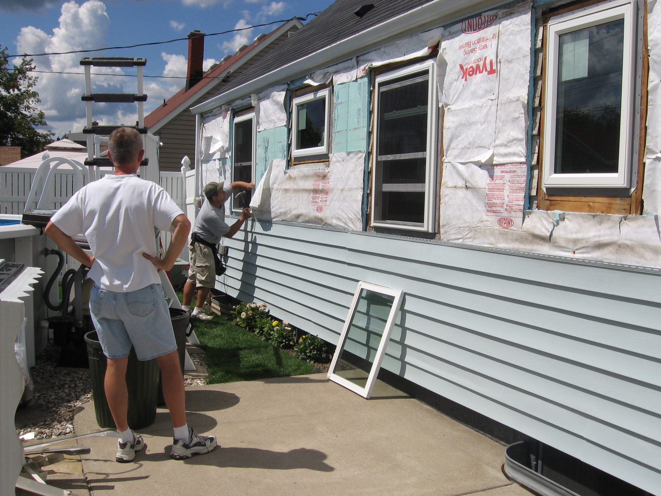 Ron installing the last window on the back of the house while Dad watches