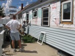 Ron installing the last window on the back of the house while Dad watches