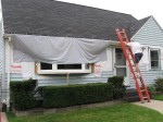 Mike putting up a tarp to protect the new window--expecting heavy rain