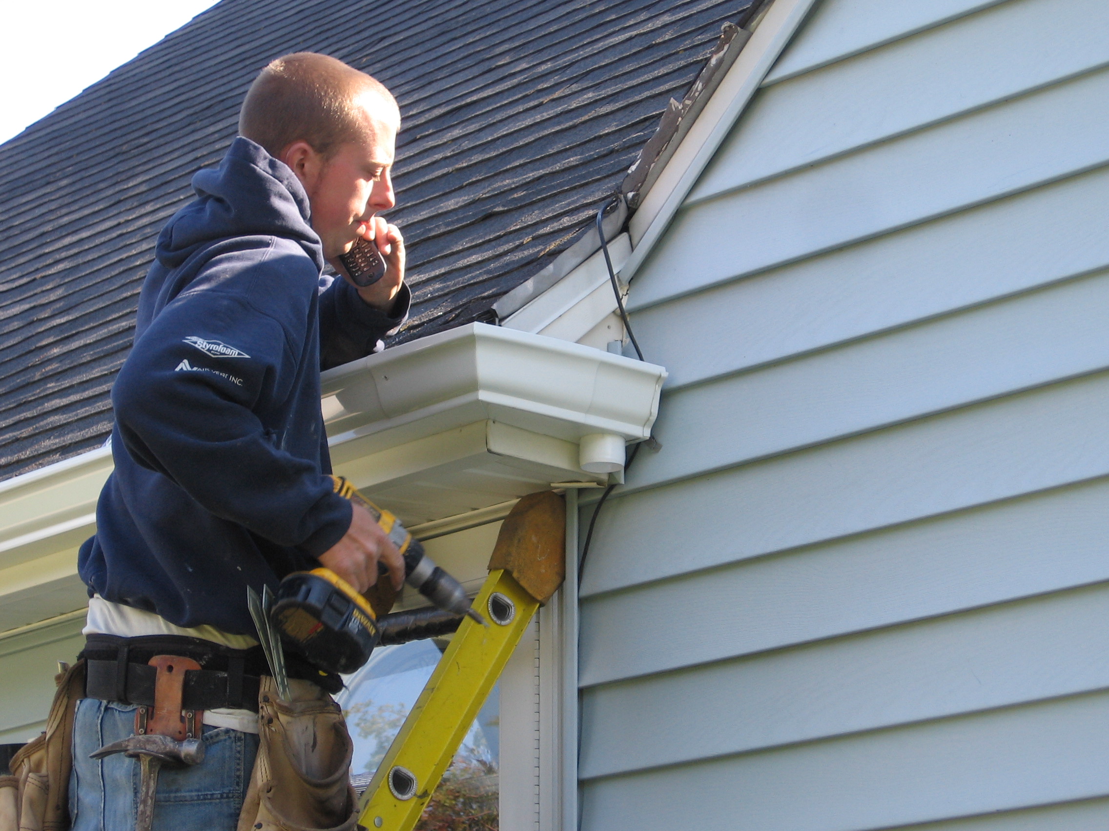 The boss on the job finishing up the gutter over the door.