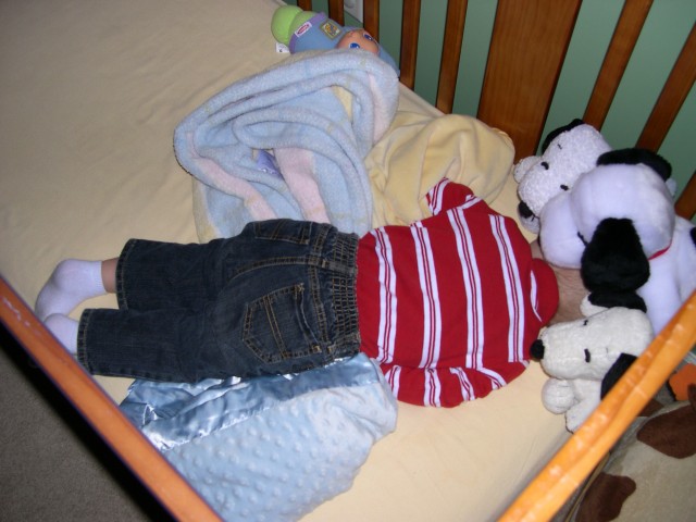 Nicky napping with his head buried under the Snoopy toys