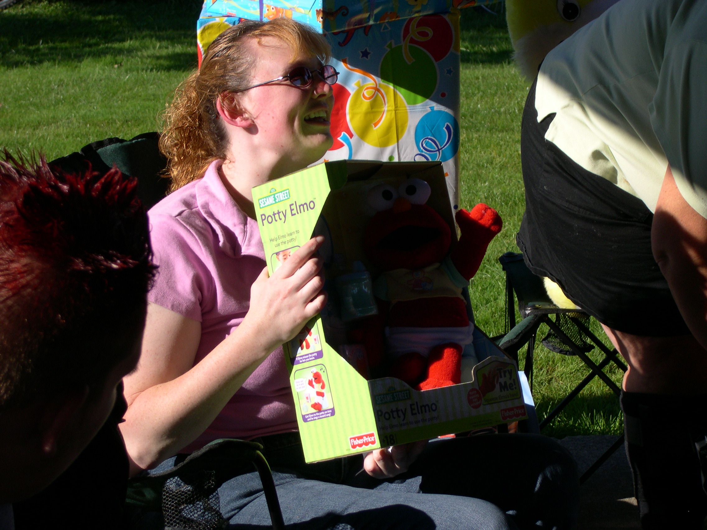 Wendy opening our gift to Tyler, Potty Elmo!